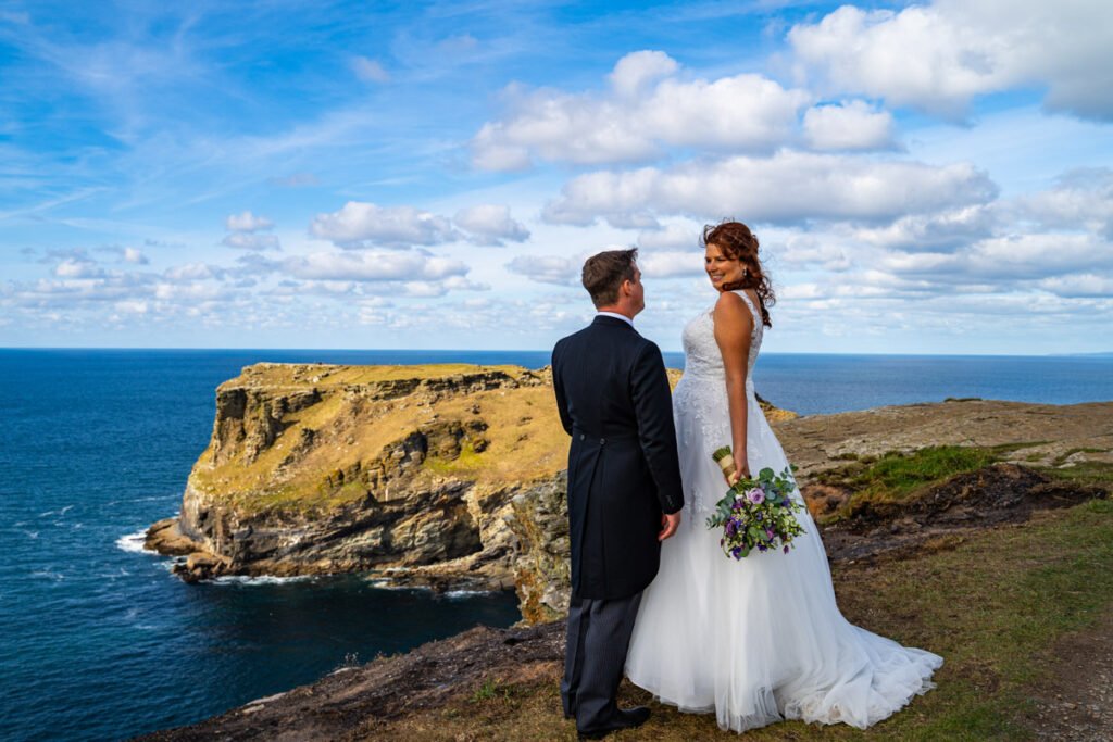 Bride and groom on the cliff overlooking tintagel island