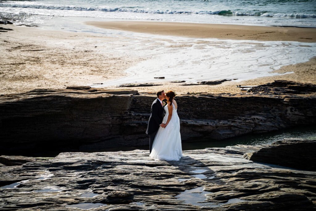 bride and groom kissing at Trebarwith strand beach in cornwall