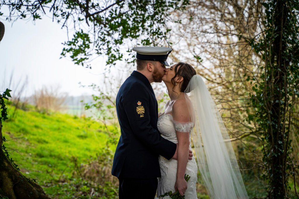 bride and groom kissing in the woods