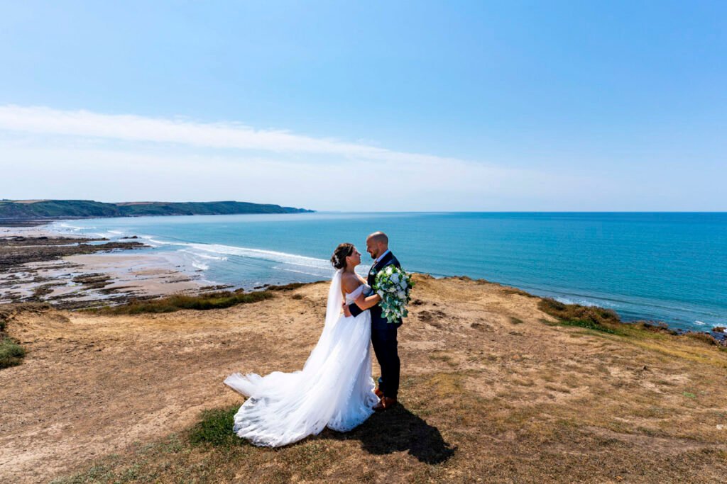 Bride and groom portrait overlooking widemouth bay Cornwall