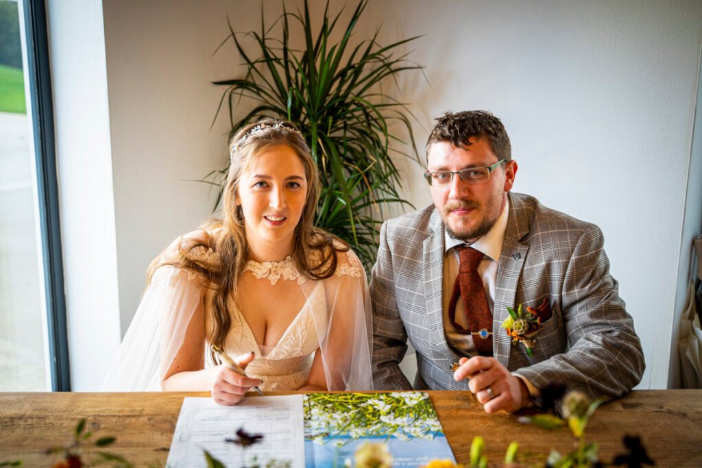 Bride and Groom signing at The barn at Pengelly Cornwall