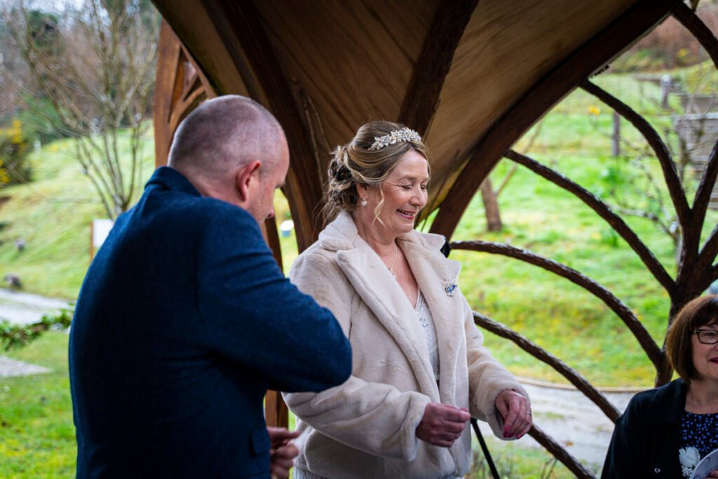 bride and groom laughing during the wedding ceremony at St Nectans Glen ceremony wedding photographer in cornwall
