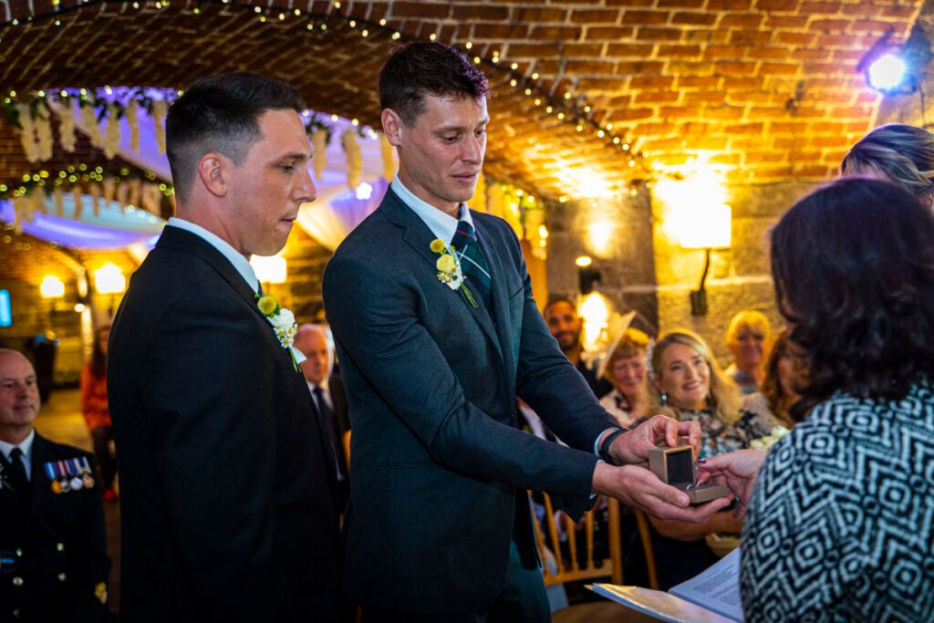 best man presenting the wedding rings during the wedding ceremony at Polhawn Fort cornwall wedding venue