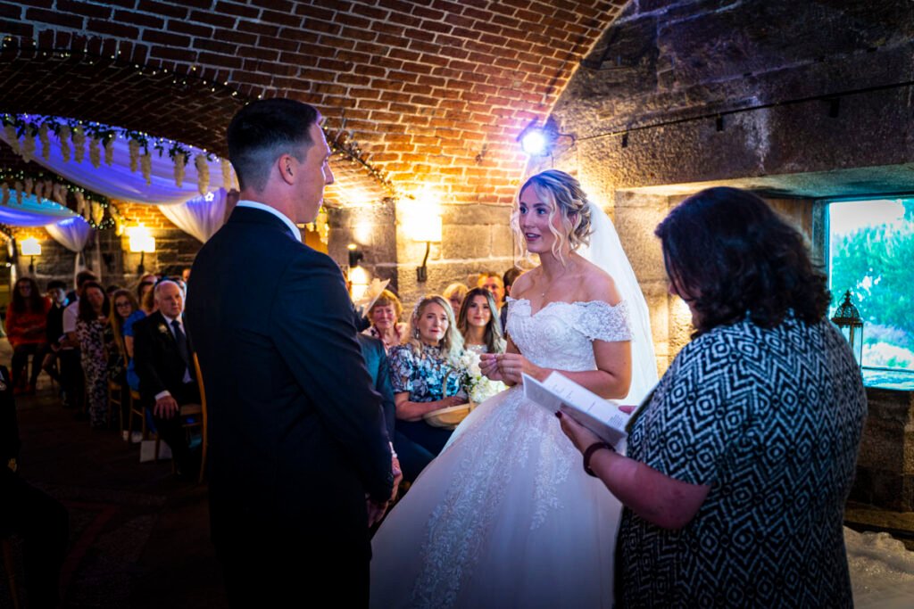 bride and groom exchanging vows at the wedding ceremony at Polhawn Fort cornwall wedding venue