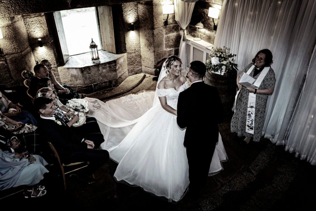 bride and groom overhead shot exchanging vows at the wedding ceremony at Polhawn Fort cornwall wedding venue B&W