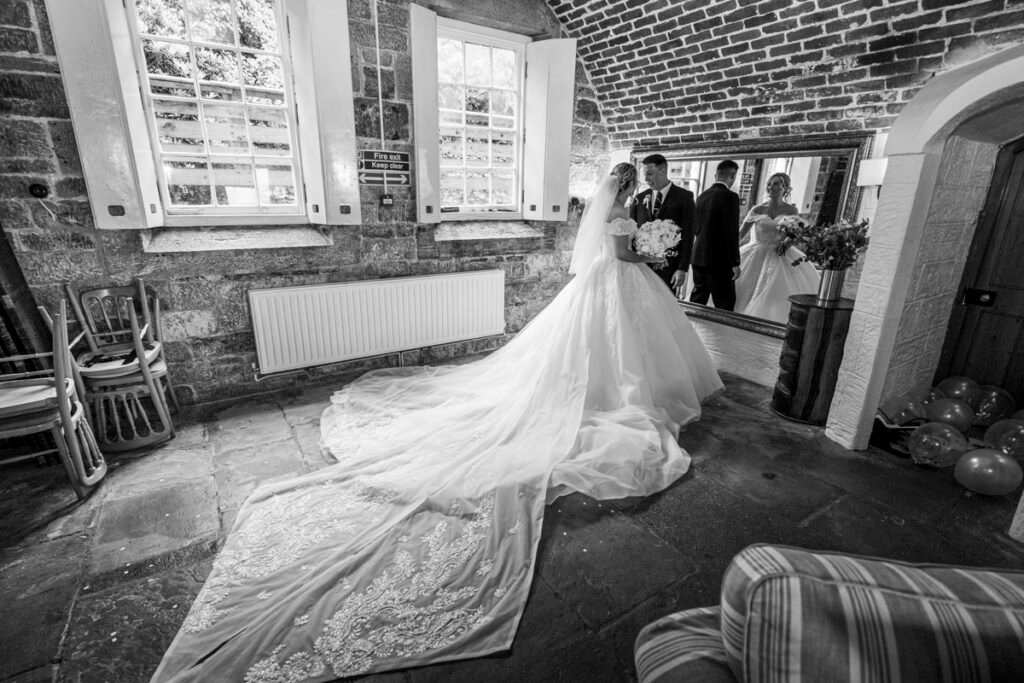 bride and groom reflection in mirror at Polhawn Fort cornwall wedding venue B&W