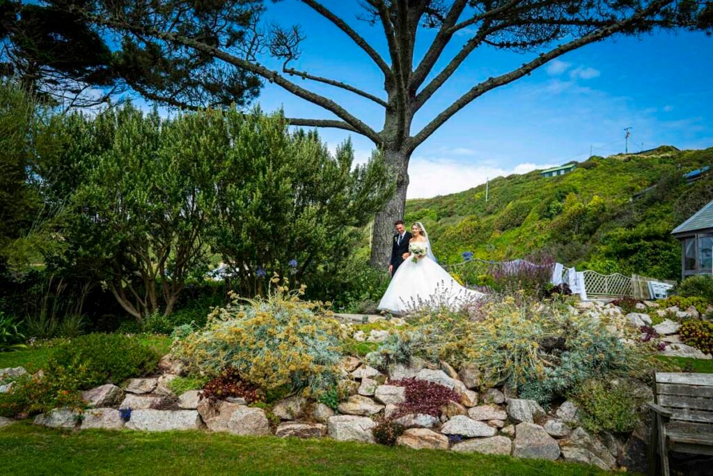 bride and groom walking in the gardens at Polhawn Fort cornwall wedding venue