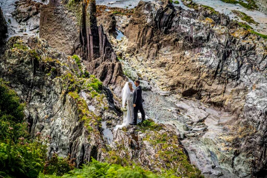 bride and groom overhead shot by a rock pool at Polhawn fort beach cornwall