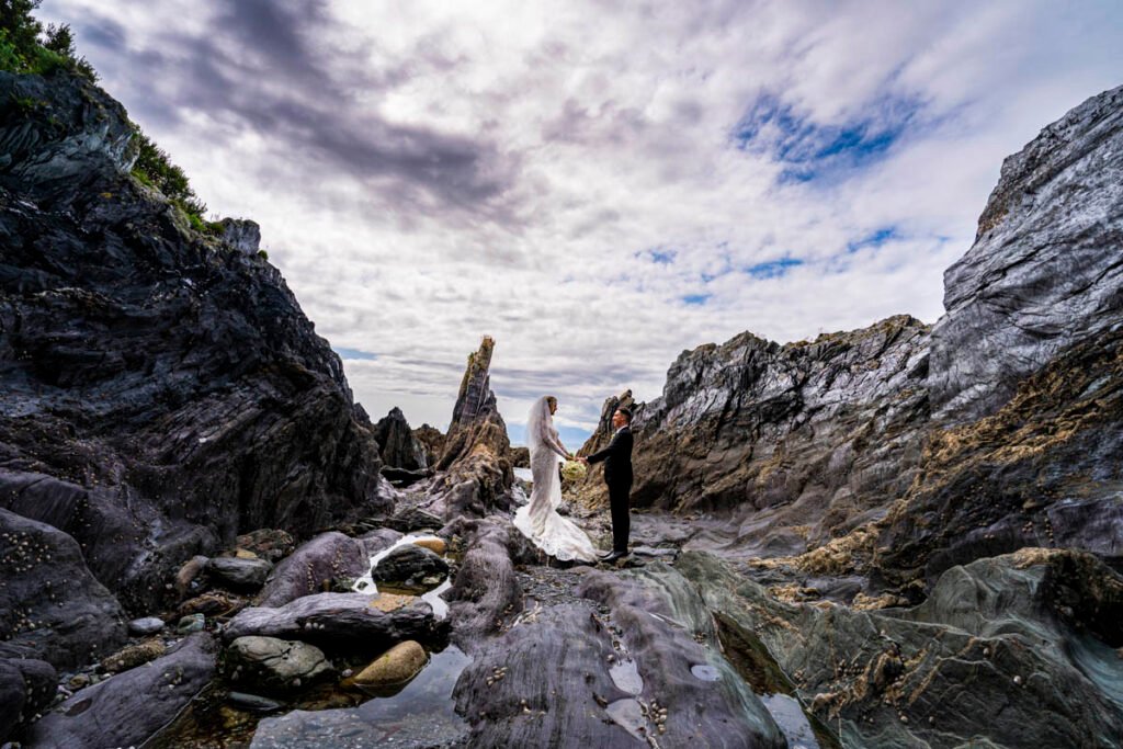 bride and groom reflected in a rock pool at Polhawn fort beach cornwall
