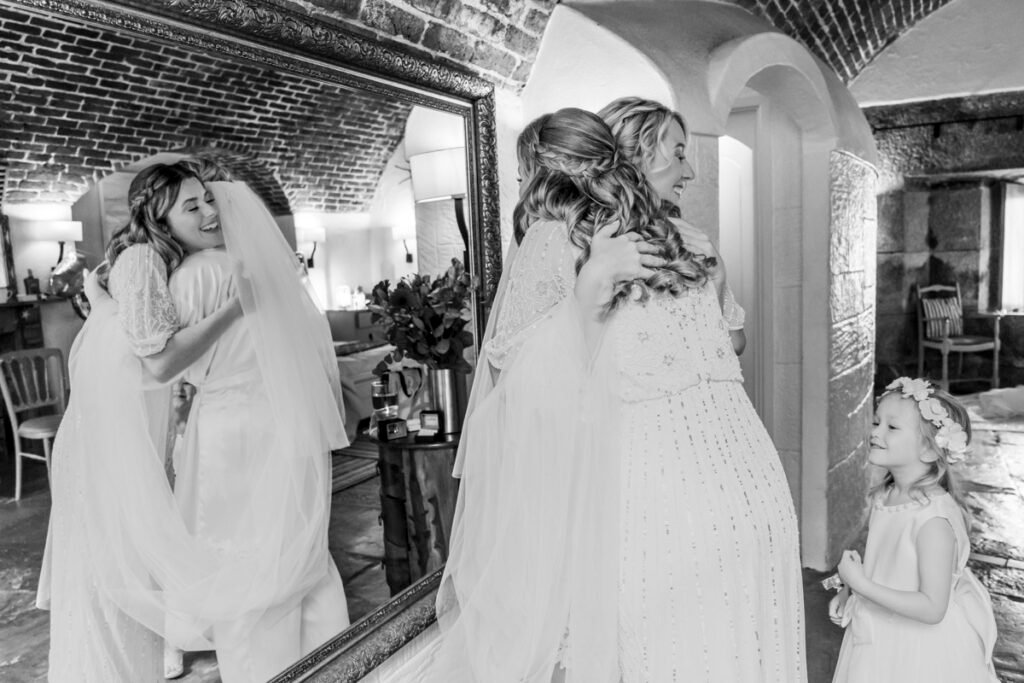 bridal party embrace reflected in the mirror B&W