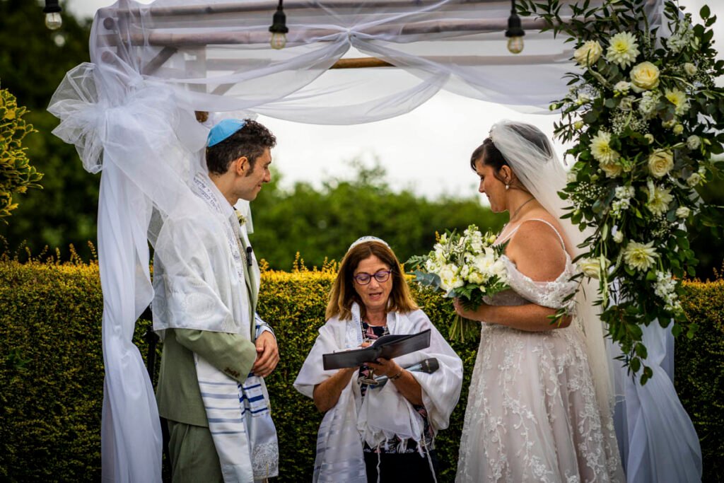 bride and groom during the outdoor wedding ceremony with rabbi