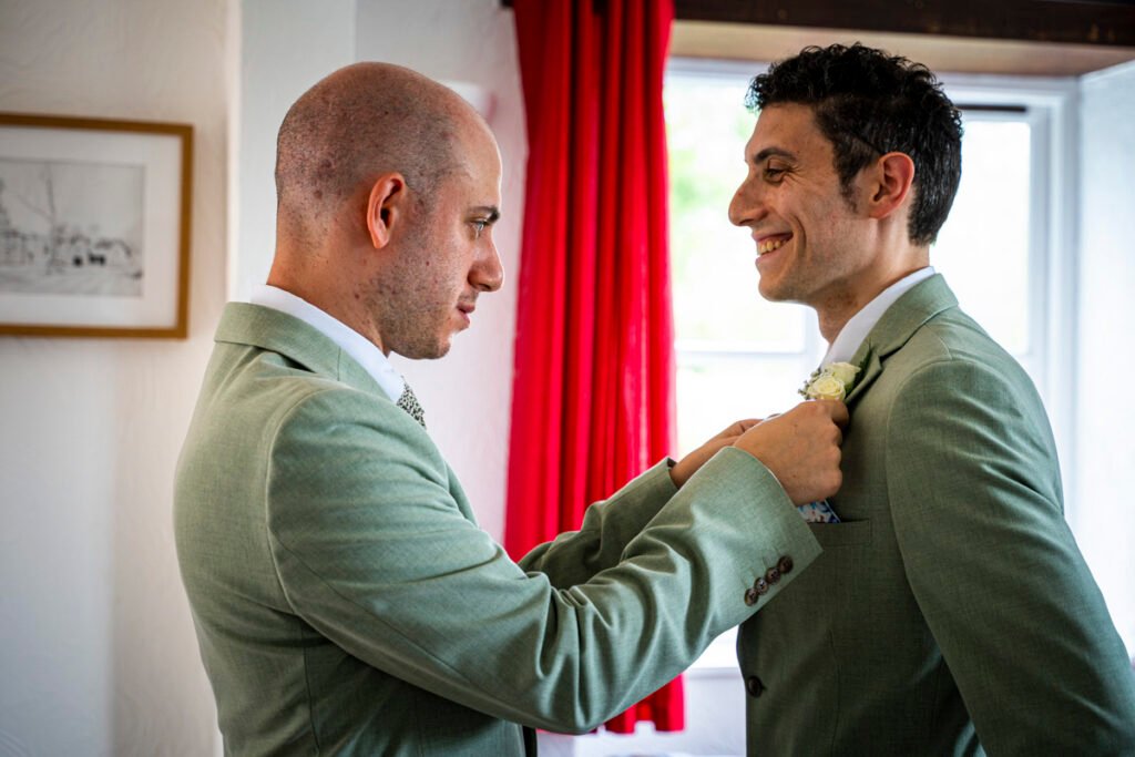 Groom and Best Man fixing the button hole