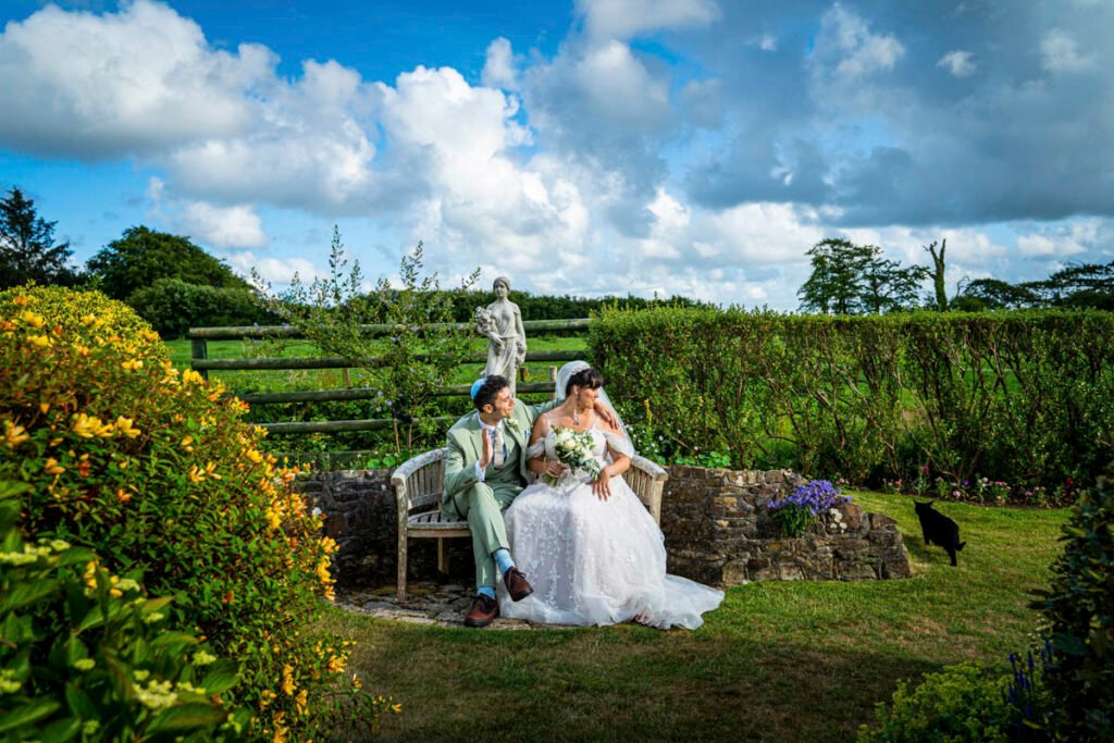 Bride and Groom sat on a bench in the garden