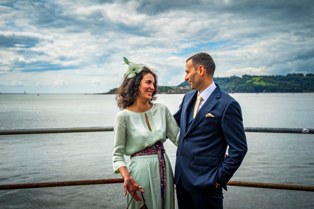 sister and groom embrace overlooking Plymouth Sound