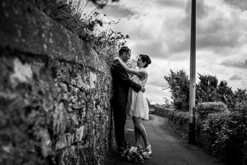 bride and groom embrace overlooking Plymouth Sound B&W