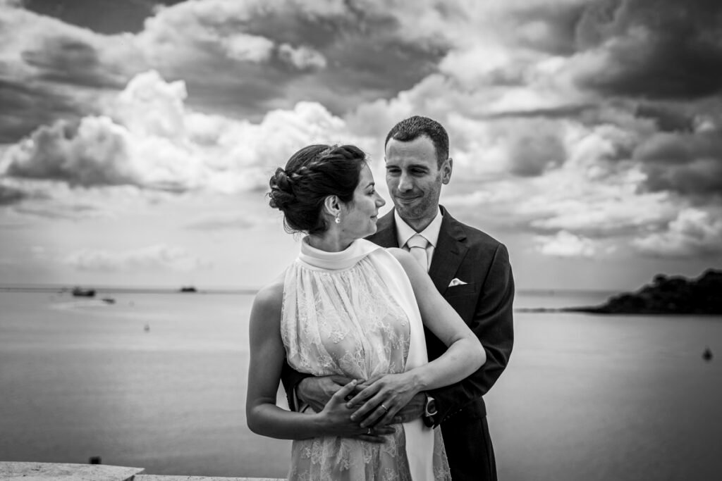 bride and groom embrace overlooking Plymouth Sound B&W