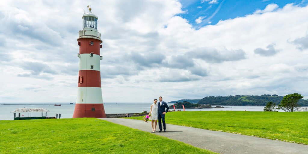 bride and groom embrace overlooking smeaton's tower on Plymouth Sound