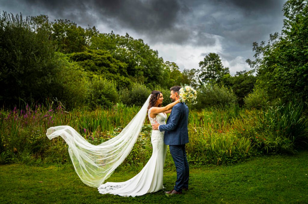 Bridde and groom in the garden with a flowing veil