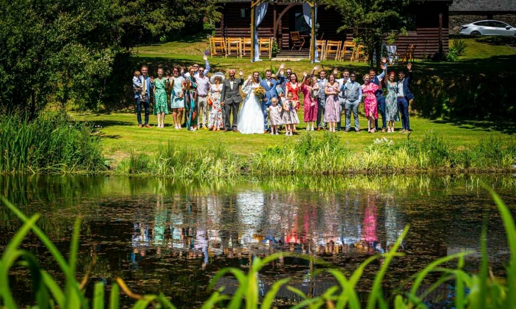 whole wedding party group shot reflected in a lake