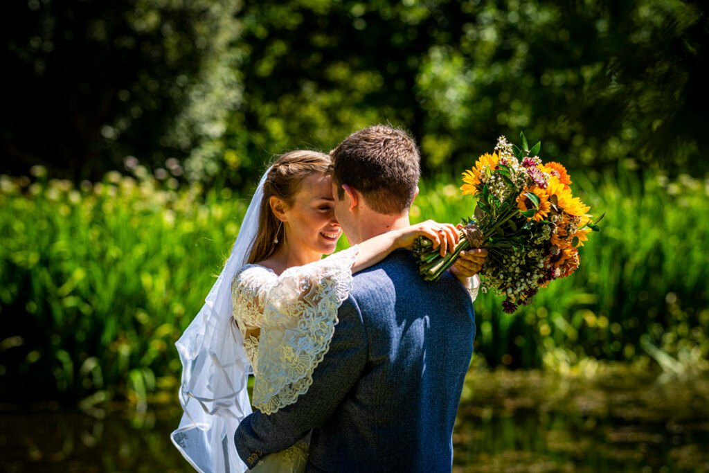bride and groom by the lake at Ta Mill