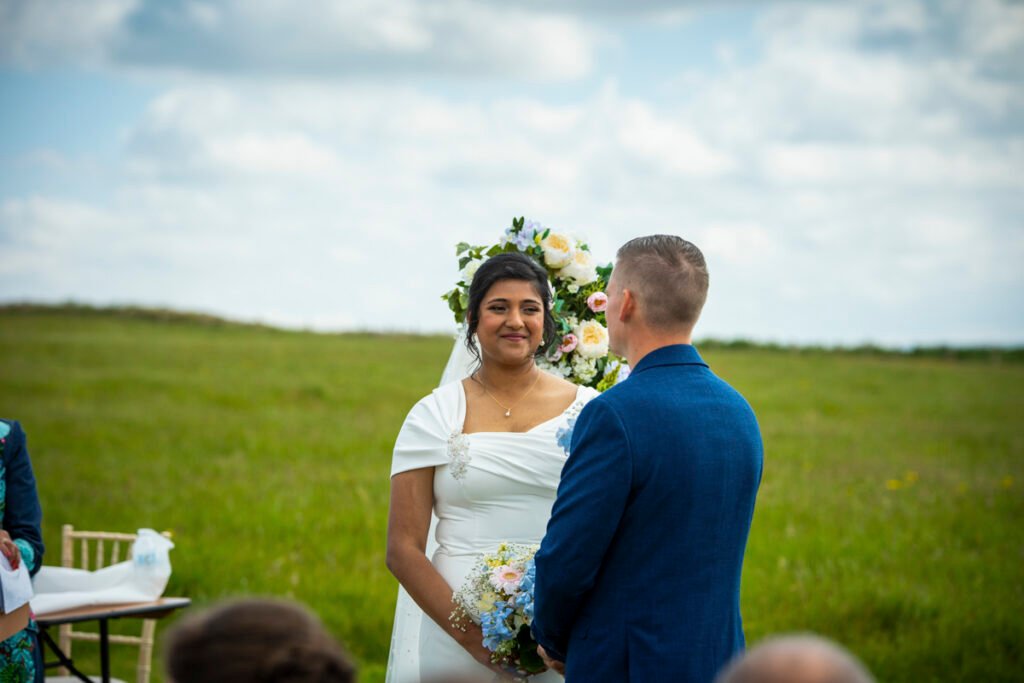 bride and groom exchanging vows outdoors