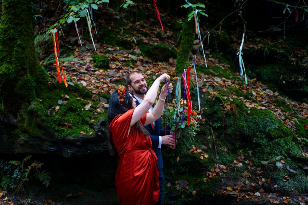 Bride and groom hanging a wedding plaque in a stream