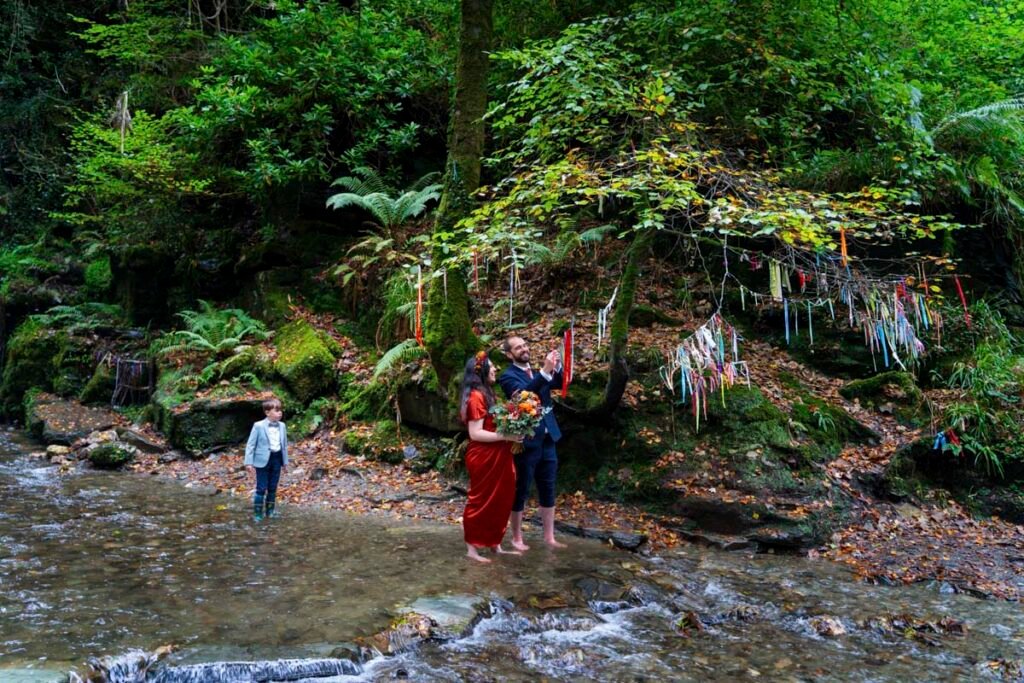 Bride and groom hanging a wedding plaque in a stream