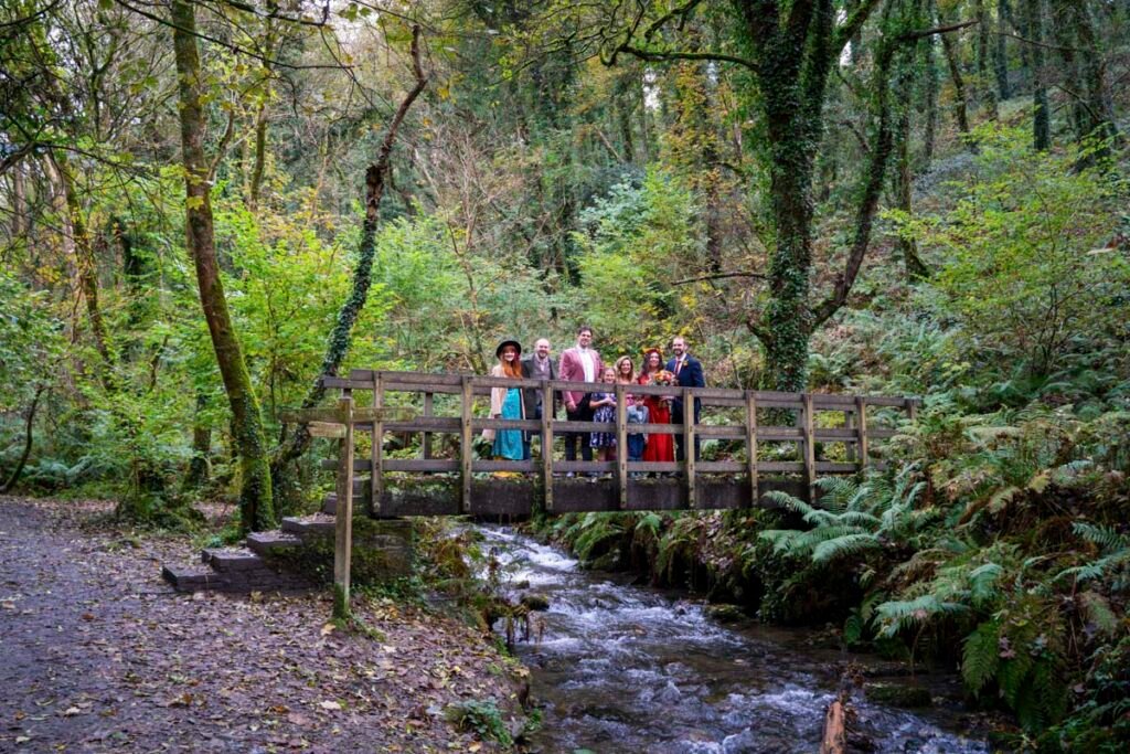 Wedding guests, Bride and Groom on a bridge over a stream