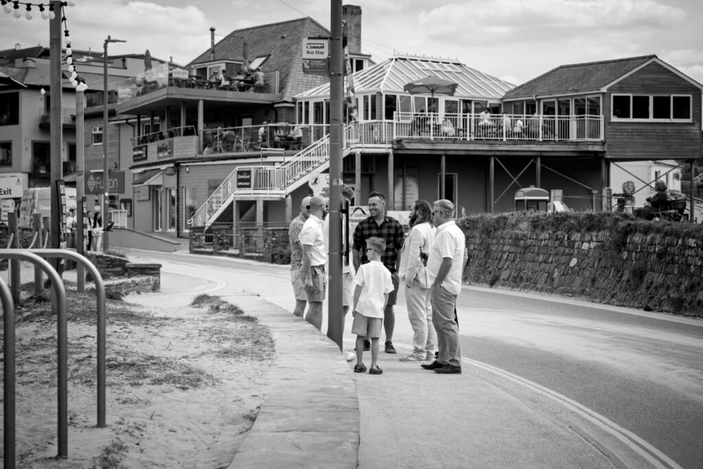 Groom and groomsmen arriving at the wedding ceremony on the cliff top overlooking the beach B&W