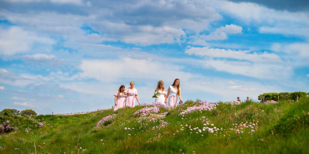 bride and bridesmaids arriving at the wedding ceremony on the cliff top overlooking the beach