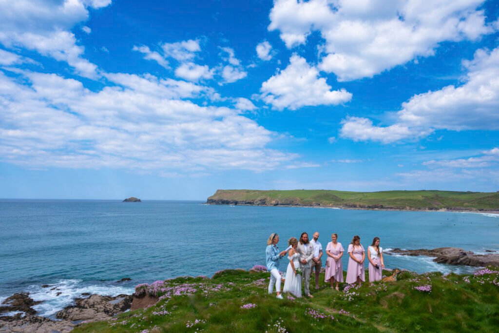 bride and groom and bridal party at the wedding ceremony on the cliff top overlooking the beach