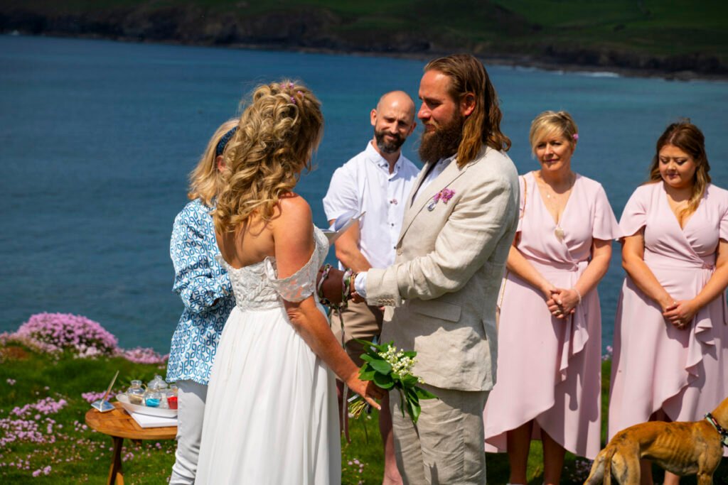 bride and groom vows at the wedding ceremony on the cliff top overlooking the beach