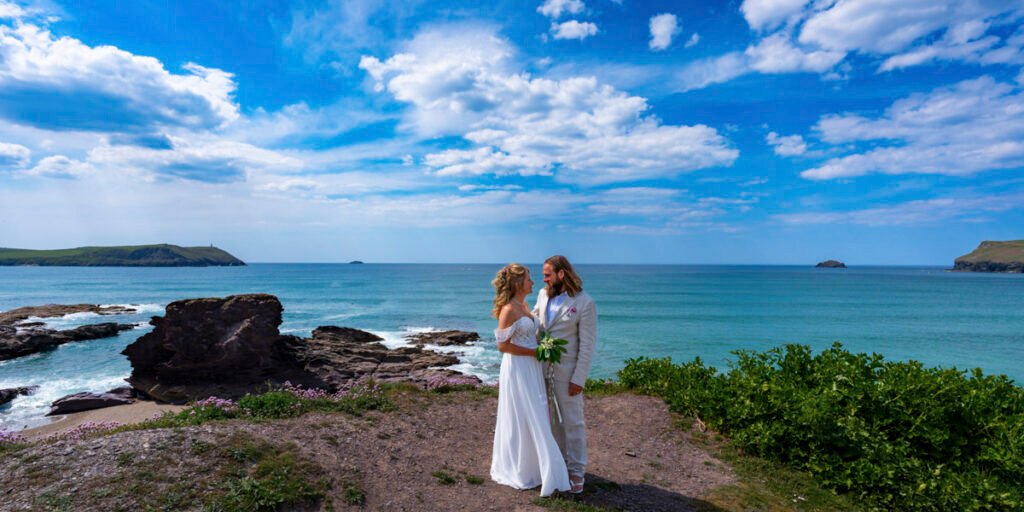 Bride and Groom posing on the cliff top overlooking the beach