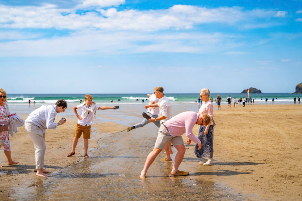 wedding guests crossing a stream on the beach