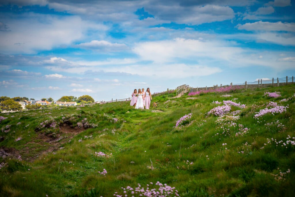 bride and bridesmaids arriving at the wedding ceremony on the cliff top overlooking the beach