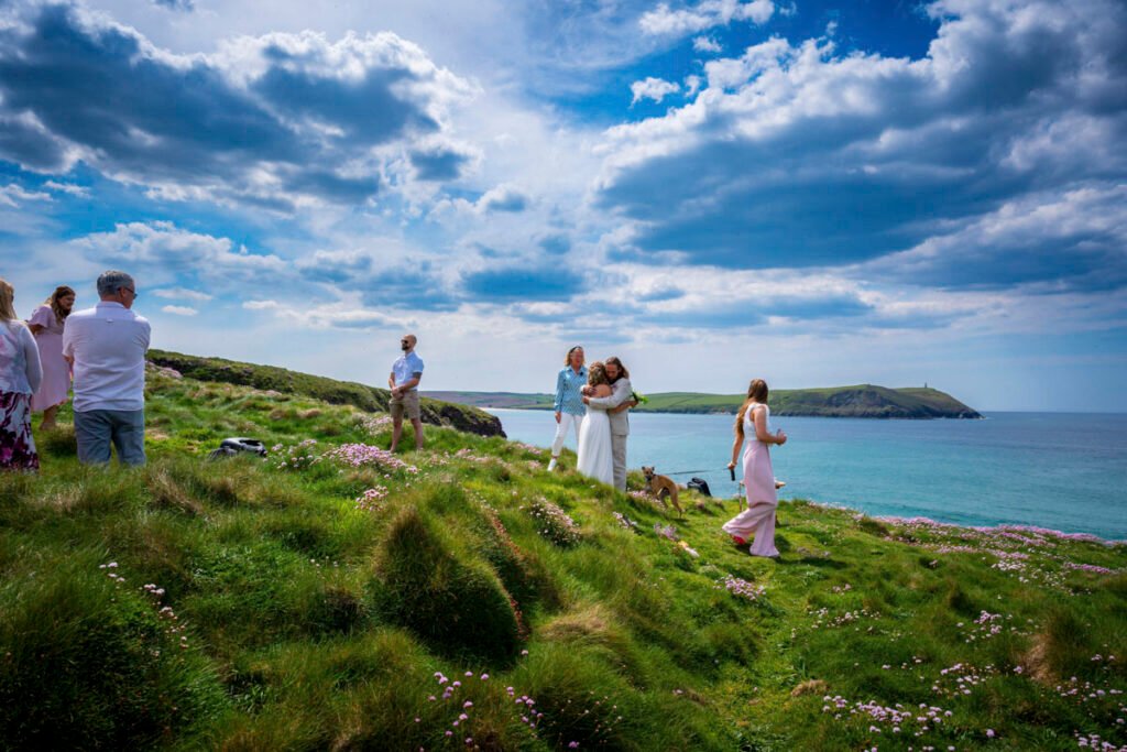 bride, groom and bridesmaids arriving at the wedding ceremony on the cliff top overlooking the beach