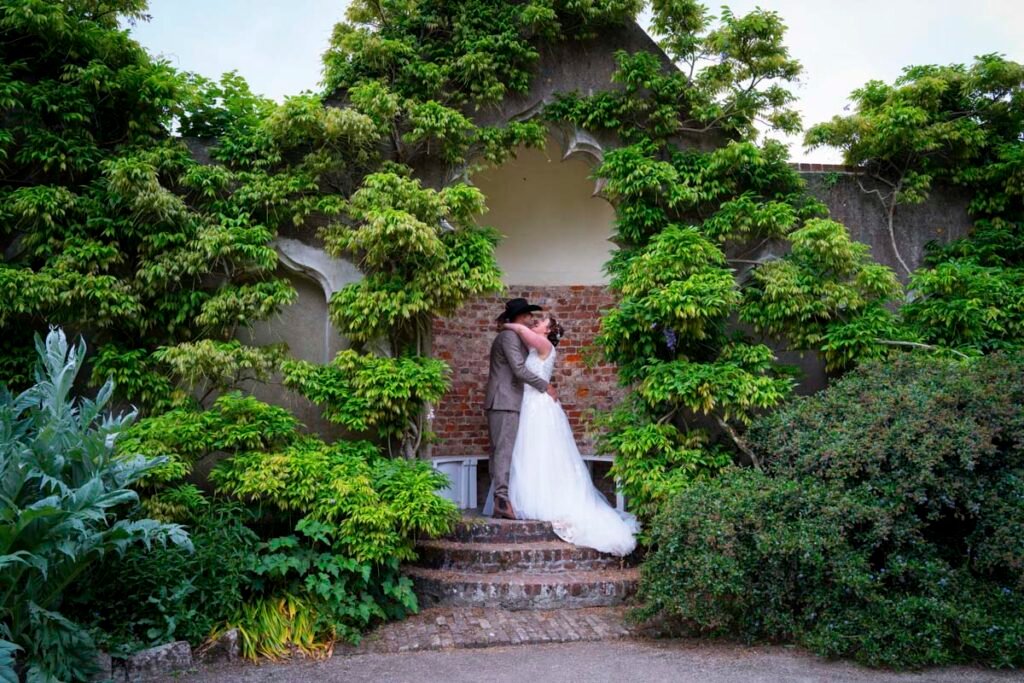 Bride and groom posing in the garden at Pencarrow House