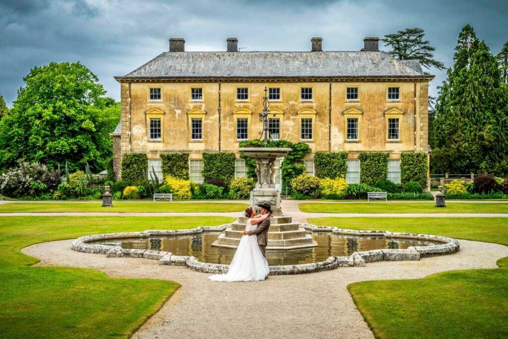 Bride and groom posing in the garden at Pencarrow House