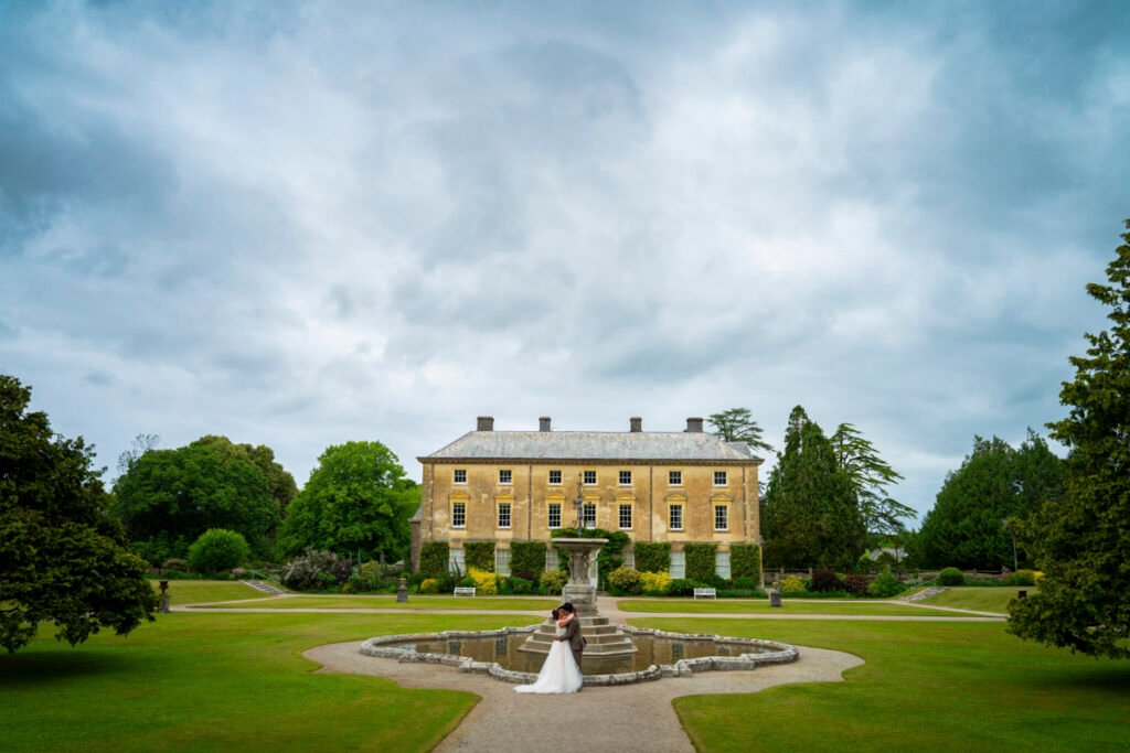 Bride and groom posing in the garden at Pencarrow House