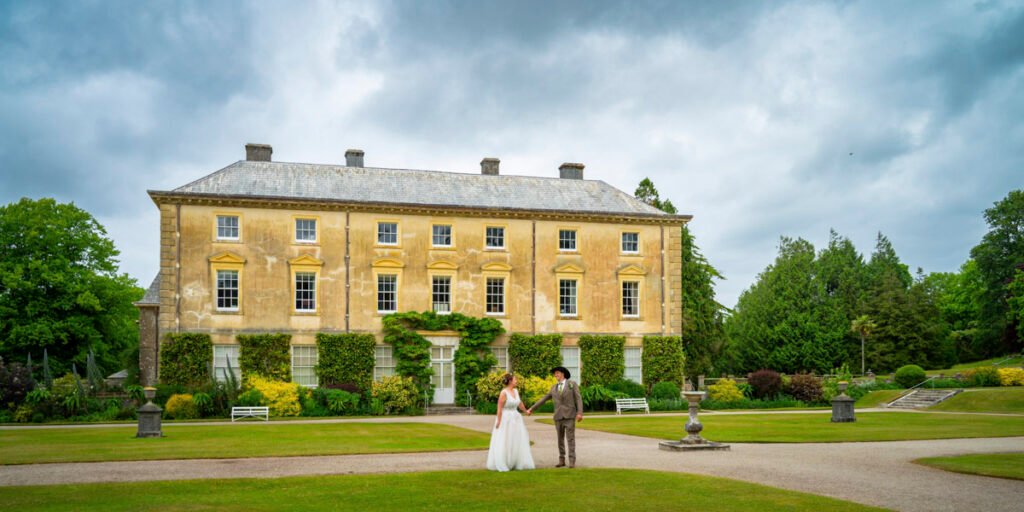 Bride and groom posing in the garden at Pencarrow House