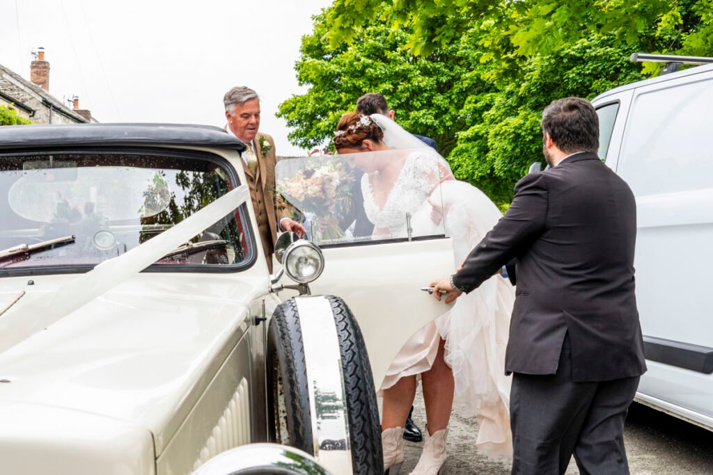 Bride getting into the wedding car