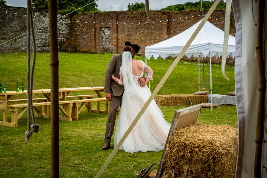 Bride and groom kissing outside the marquee